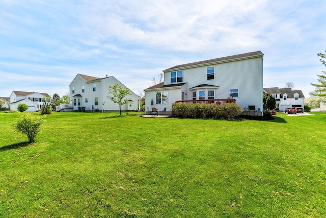 back of property with a wooden deck and a lawn