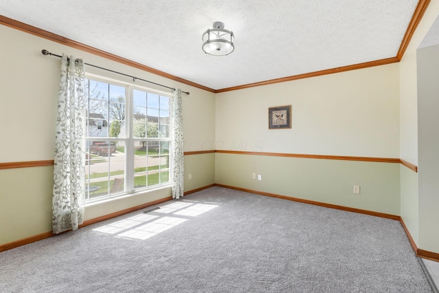 carpeted spare room with ornamental molding, baseboards, and a healthy amount of sunlight