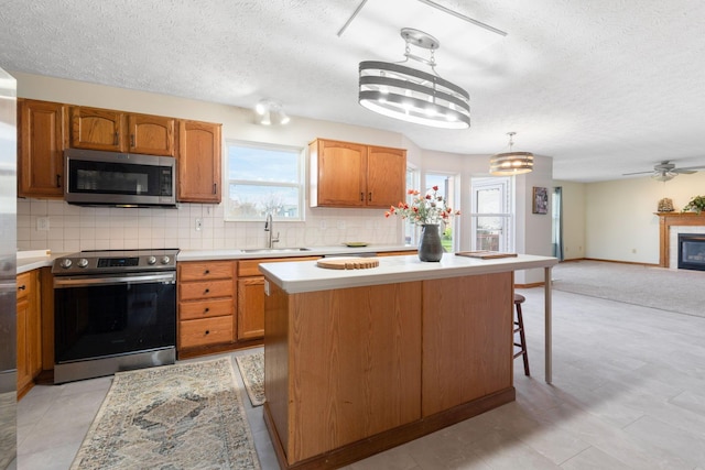 kitchen featuring light countertops, a textured ceiling, stainless steel appliances, and a sink