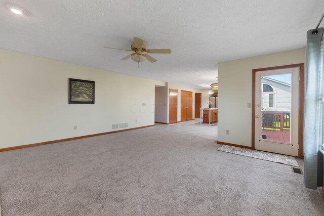 spare room featuring light carpet, a ceiling fan, visible vents, and baseboards