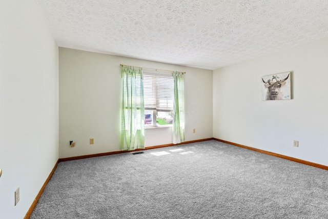 carpeted empty room featuring visible vents, baseboards, and a textured ceiling