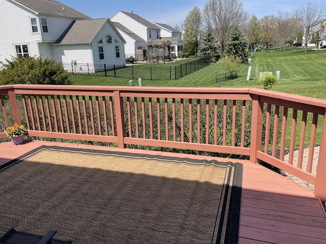 deck featuring fence, a yard, and a residential view