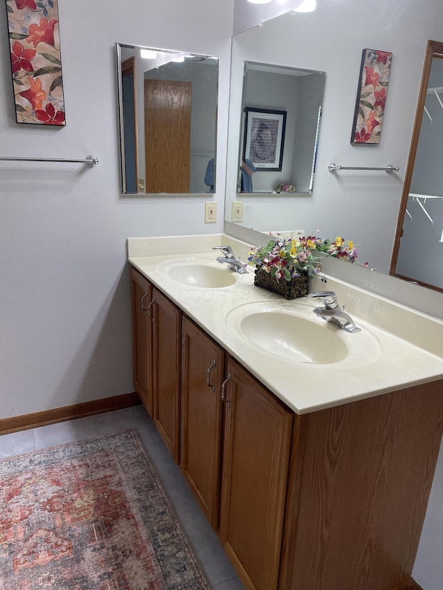 bathroom featuring tile patterned flooring, a sink, and double vanity
