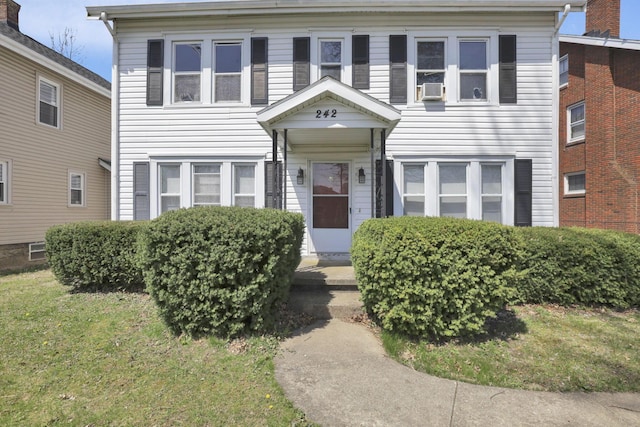 view of front of house with a front lawn and cooling unit
