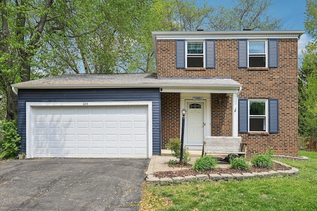 traditional-style home featuring an attached garage, driveway, and brick siding