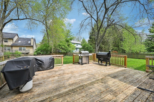 wooden terrace featuring a lawn, a fenced backyard, and area for grilling