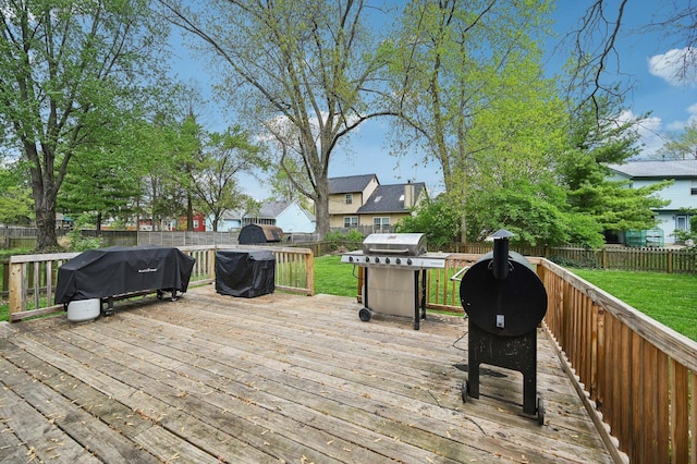 wooden terrace with a fenced backyard, a yard, and area for grilling