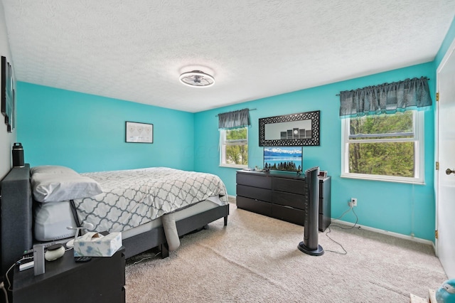 carpeted bedroom with baseboards and a textured ceiling