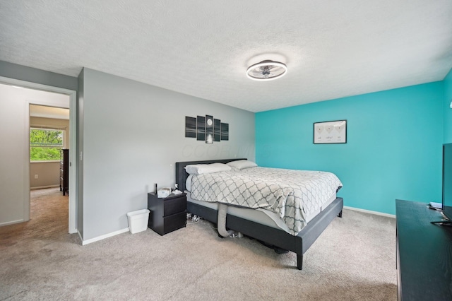 carpeted bedroom with baseboards and a textured ceiling