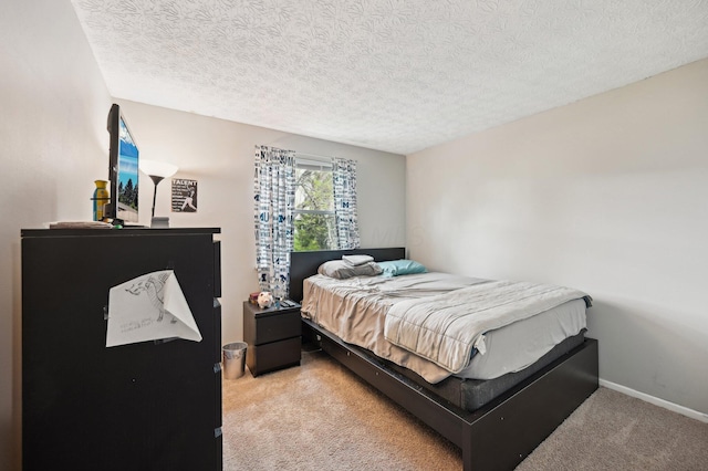 bedroom featuring carpet floors, baseboards, and a textured ceiling