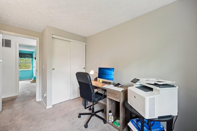 carpeted home office with visible vents, a textured ceiling, and baseboards