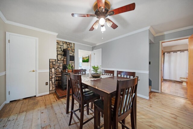 49 Front St, Orient, OH 43146 - dining space featuring a wood stove, ornamental molding, baseboards, light wood-type flooring, and a ceiling fan