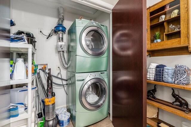 laundry area with laundry area, stacked washer / dryer, and tile patterned floors