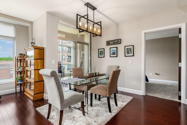 dining room featuring baseboards, an inviting chandelier, and dark wood-style floors