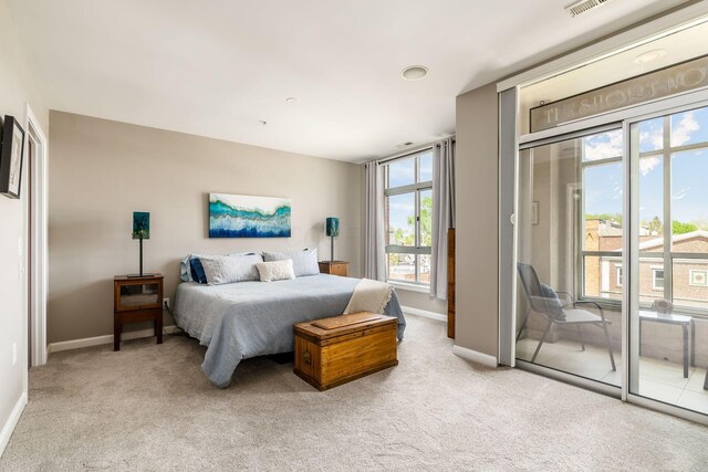 bedroom with baseboards, access to exterior, and light carpet