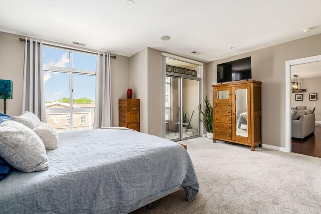 bedroom featuring access to outside, baseboards, visible vents, and carpet