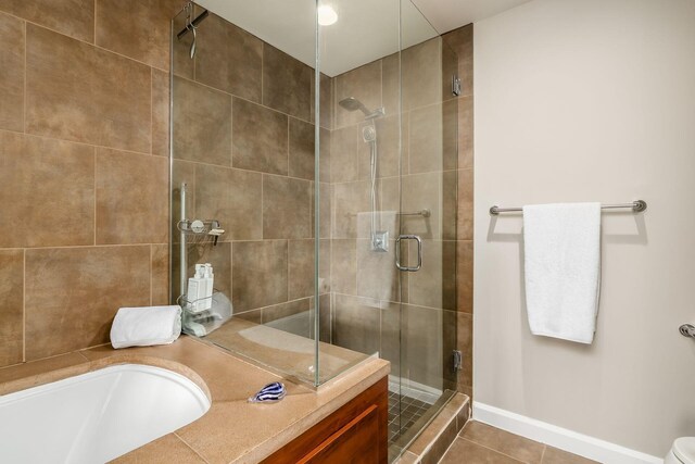 full bath featuring tile patterned floors, baseboards, and a stall shower