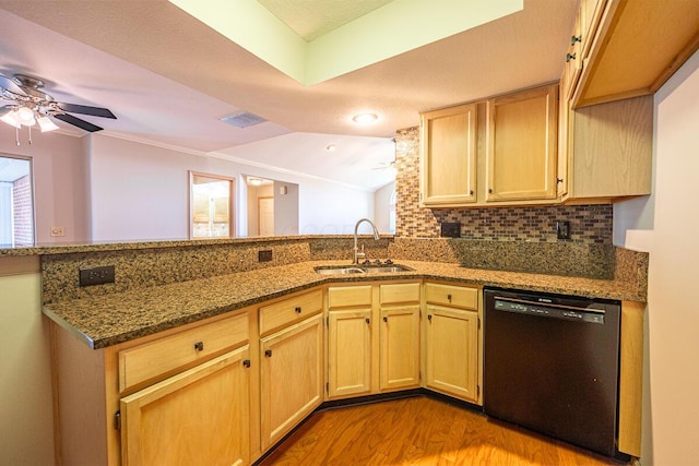 kitchen with dark stone counters, a ceiling fan, wood finished floors, a sink, and black dishwasher