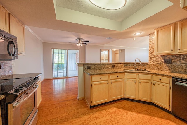 kitchen with ornamental molding, a sink, light wood-style floors, black appliances, and a peninsula