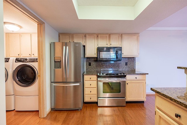 kitchen featuring decorative backsplash, washer / dryer, appliances with stainless steel finishes, and light wood-style floors