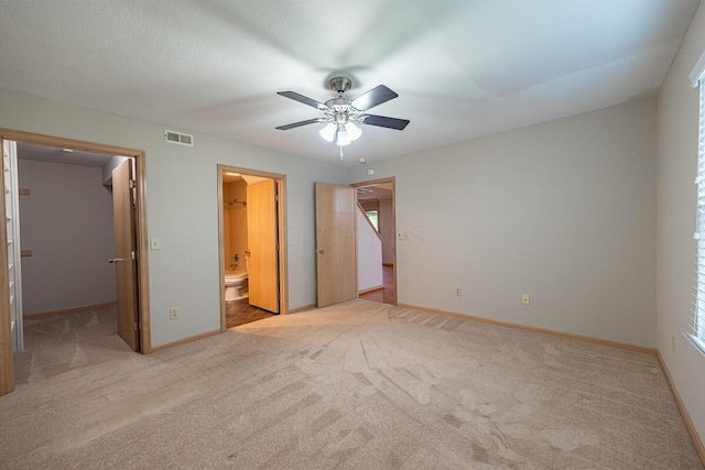 unfurnished bedroom featuring a walk in closet, carpet floors, visible vents, and baseboards