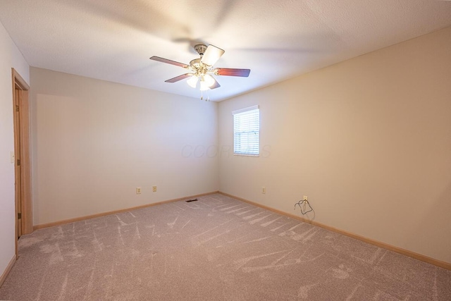unfurnished room with light colored carpet, ceiling fan, and baseboards