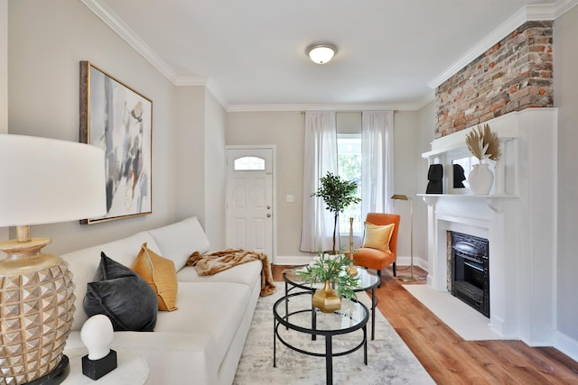 living area featuring a fireplace with flush hearth, baseboards, crown molding, and wood finished floors