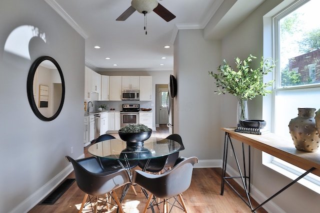 dining room with baseboards, ornamental molding, visible vents, and a wealth of natural light