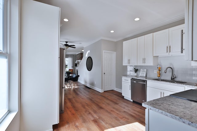 kitchen featuring white cabinets, a sink, ceiling fan, crown molding, and stainless steel dishwasher