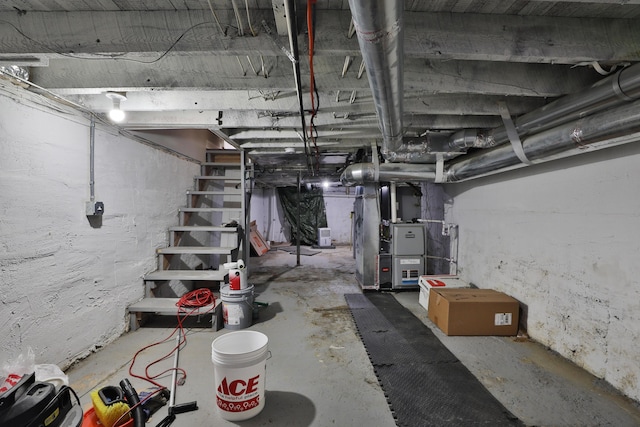 unfinished basement with heating unit and stairway