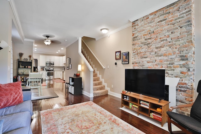 living area with baseboards, a ceiling fan, dark wood-style floors, crown molding, and stairway
