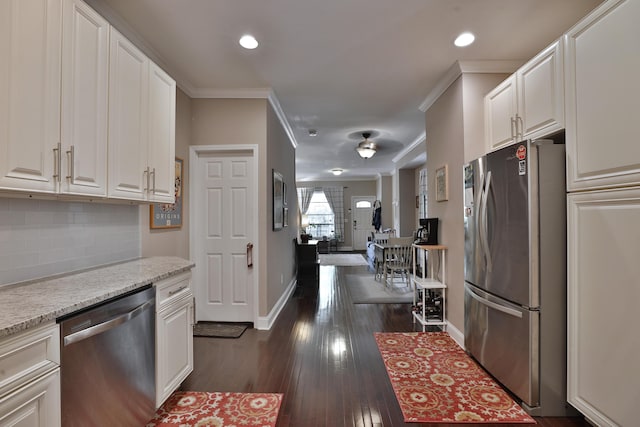 kitchen featuring decorative backsplash, baseboards, white cabinetry, and appliances with stainless steel finishes