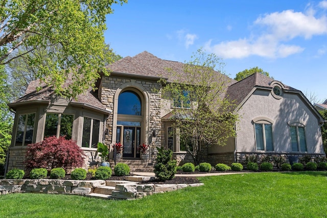 3906 Tarrington Ln, Columbus, OH 43220 - french country style house featuring a shingled roof, a front lawn, stucco siding, and stone siding