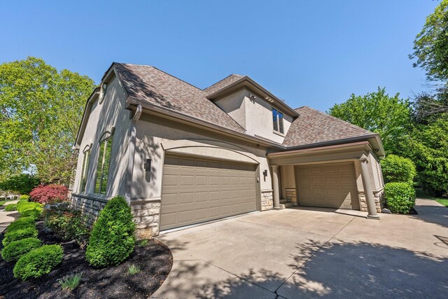 3906 Tarrington Ln, Columbus, OH 43220 - view of front of house with concrete driveway, stucco siding, an attached garage, and stone siding