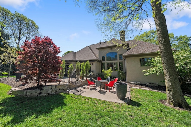 3906 Tarrington Ln, Columbus, OH 43220 - back of house featuring stucco siding, a chimney, a shingled roof, a patio area, and a yard