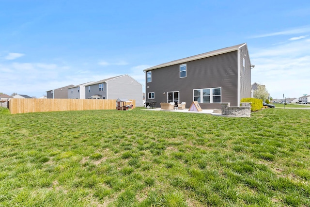 rear view of property with a lawn, fence, and a patio area