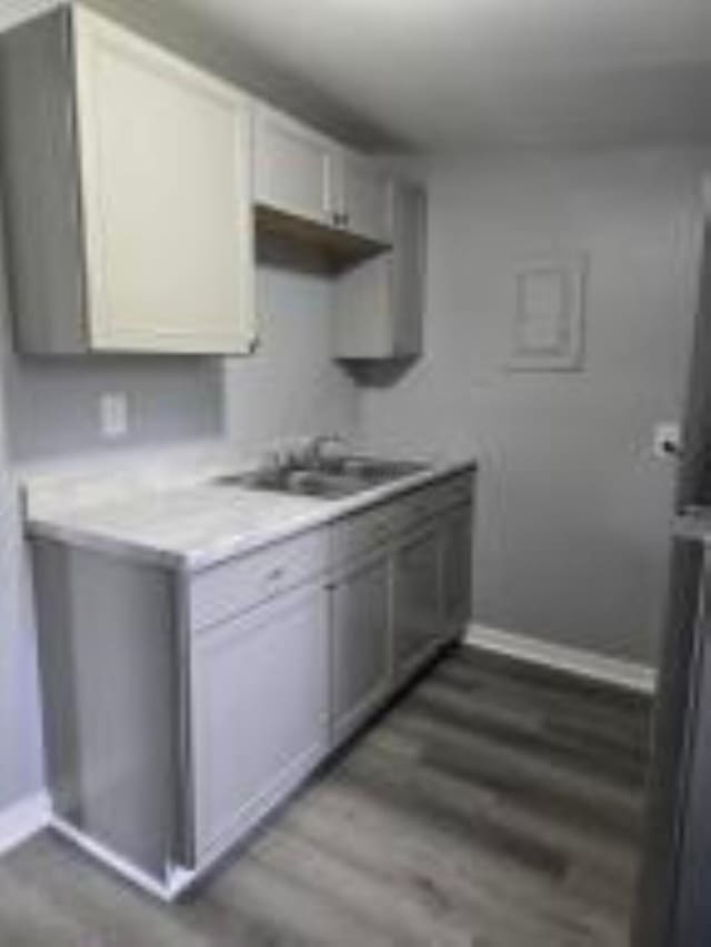 404 Sherman Ave, Springfield, OH 45503 - kitchen featuring baseboards, light countertops, wood finished floors, and a sink