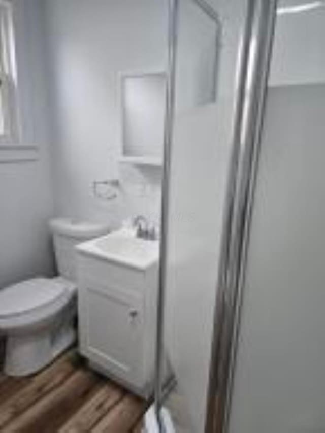 404 Sherman Ave, Springfield, OH 45503 - full bathroom with a stall shower, vanity, toilet, and wood finished floors