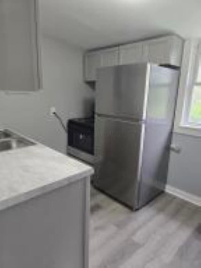 404 Sherman Ave, Springfield, OH 45503 - kitchen with stainless steel appliances, light wood finished floors, gray cabinetry, light countertops, and baseboards