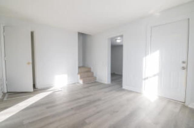 404 Sherman Ave, Springfield, OH 45503 - unfurnished living room featuring wood finished floors and stairs