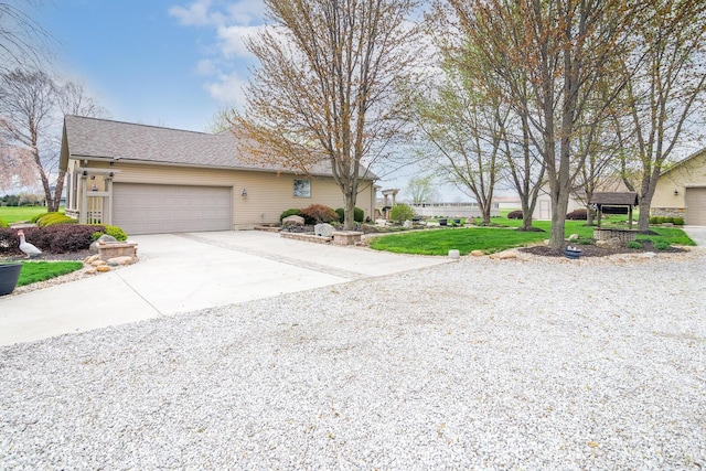 ranch-style house featuring a garage, a shingled roof, a front yard, and concrete driveway