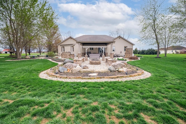 back of house featuring a yard, a fire pit, and a patio area