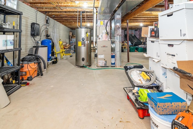 unfinished below grade area featuring heating unit and water heater