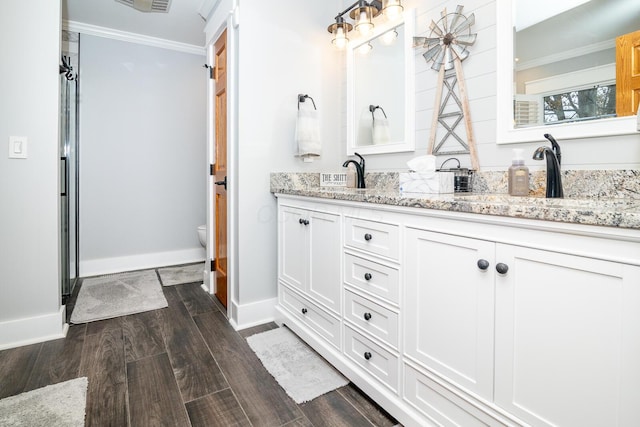 full bathroom featuring baseboards, wood finished floors, double vanity, and a sink