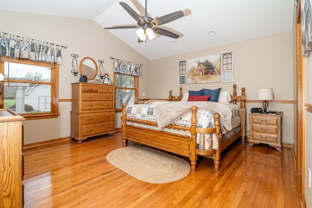 bedroom featuring vaulted ceiling, multiple windows, and light wood finished floors