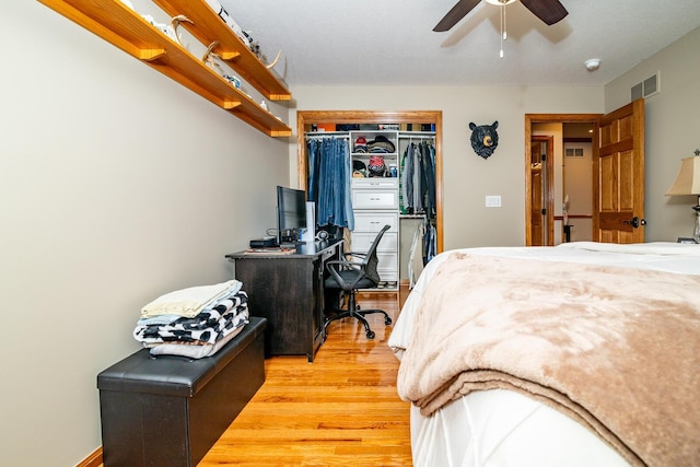 bedroom with ceiling fan, light wood-style floors, visible vents, and a closet