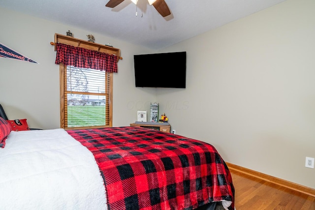 bedroom with ceiling fan, baseboards, and wood finished floors