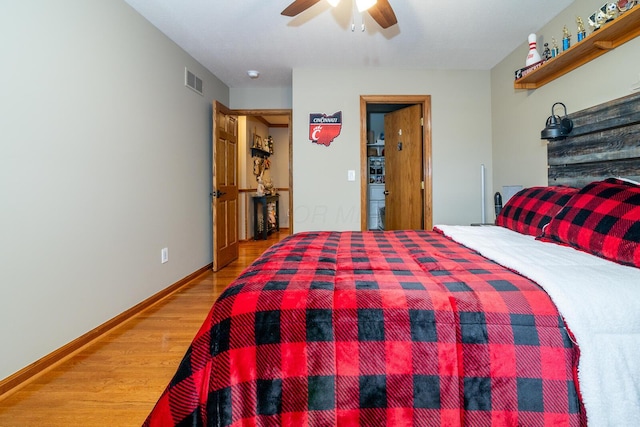 bedroom with baseboards, wood finished floors, visible vents, and ceiling fan