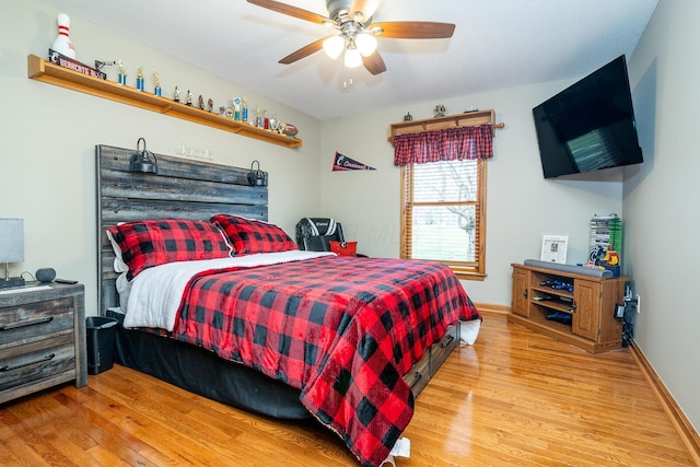 bedroom featuring light wood finished floors, a ceiling fan, and baseboards