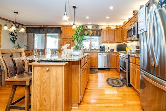 kitchen featuring a kitchen bar, a healthy amount of sunlight, a center island, and stainless steel appliances
